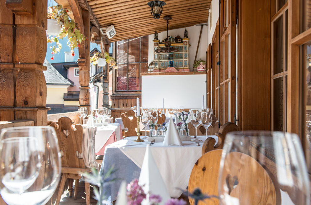 Die Restauranttische auf dem Balkon im Seewirt Zauner mit Blick auf die historische Stadt Hallstatt und den Hallstätter See