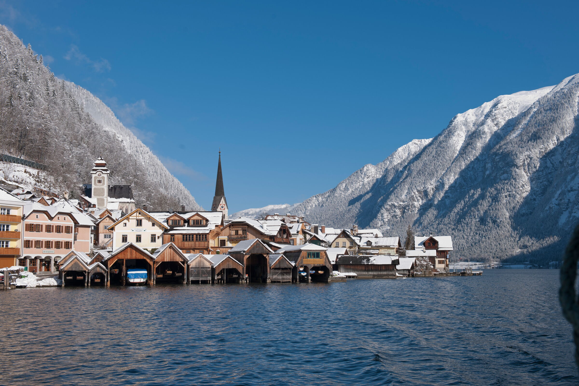 View from Lake Hallstatt to the snow-covered UNESCO World Heritage Site of Hallstatt and the surrounding snow-covered mountain ranges of the Salzkammergut