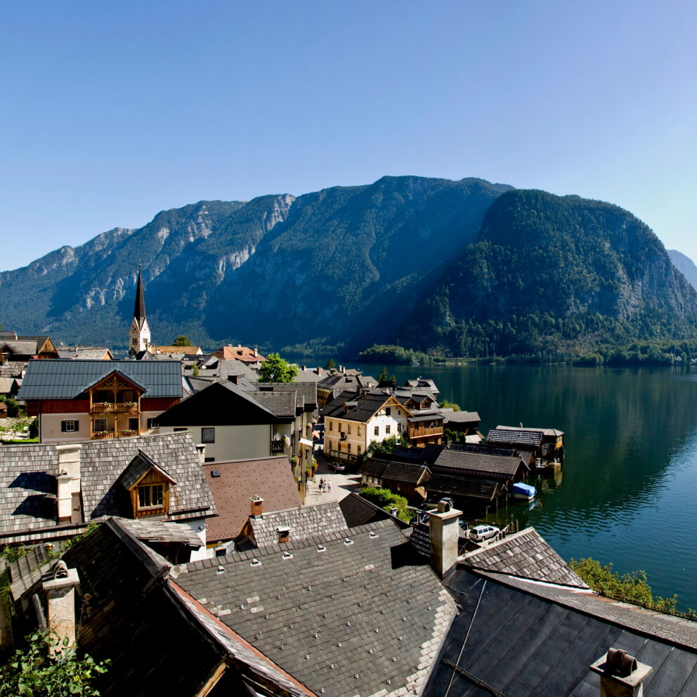 Blick über die Dächer der Stadt Hallstatt und den Hallstätter See auf die atemberaubenden Bergketten des Salzkammergutes